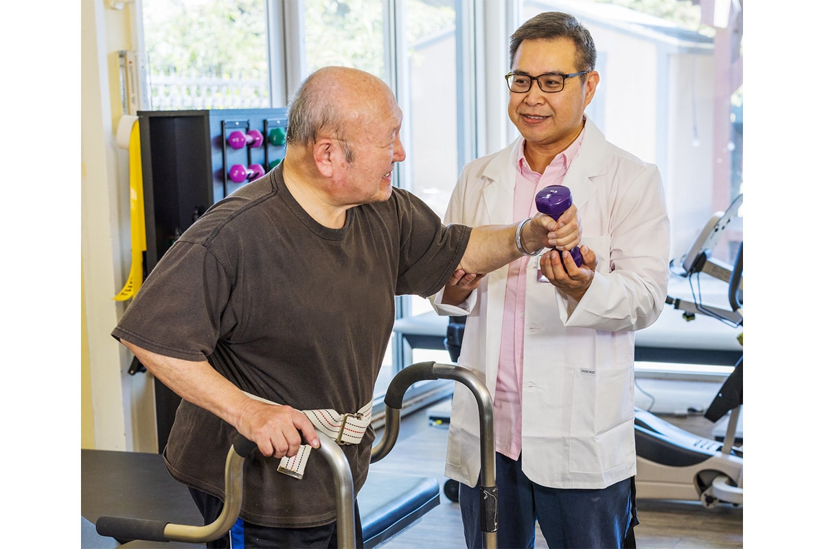 Oakwood Gardens rehab therapist with a resident in the gym
