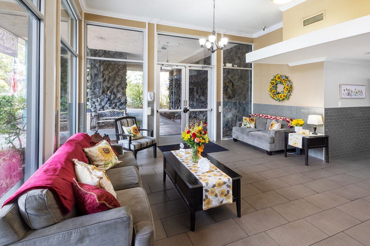 soft seating and flowers in the Oakwood Gardens lobby with reception desk