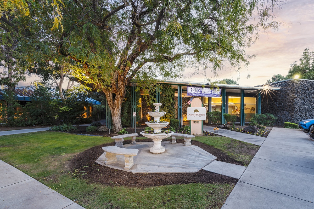 Front of the Oakwood Gardens facility, trees and benches
