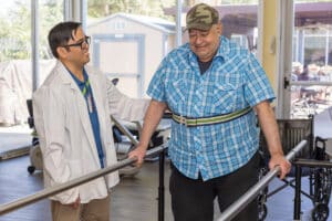 Rehab therapist with a resident in the gym